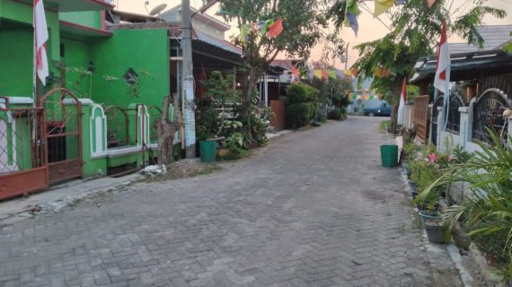 Caption: Rumah keluarga Rakim (paling kiri) bercat hijau, hanya berjarak beberapa langkah dari kediaman Rahayu Dwi Martani (dua dari kanan) dengan gerbang coklat di Jl Imam Bonjol RT 1/RW 16, Mejasem Barat, Kecamatan Kramat, Kabupaten Tegal. Foto diambil 20 Juli 2021.